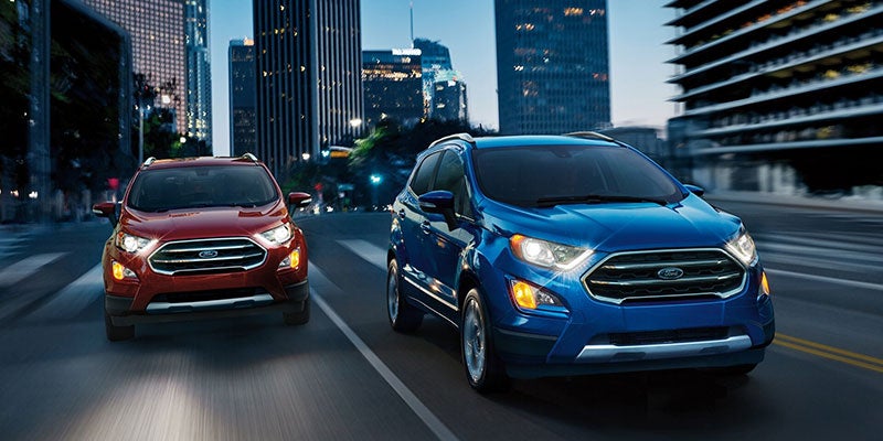A blue and a red Ford EcoSport driving beside each other on the highway. | Ford dealer in Little Rock, AR.