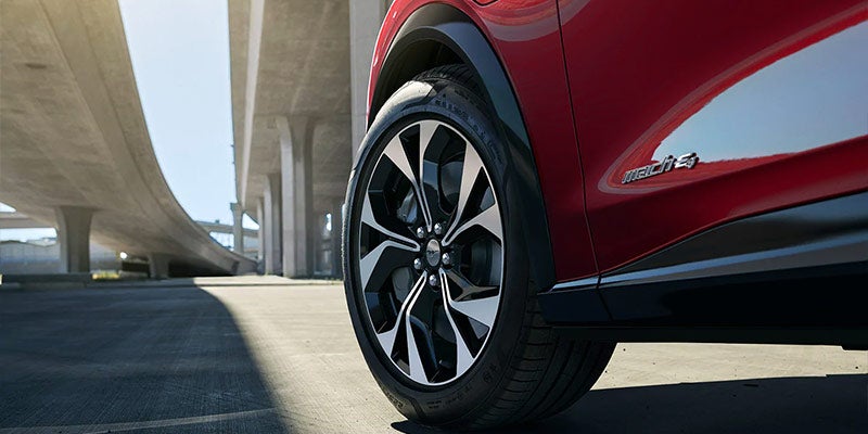 Close view of the front driver side tire of a red 2021 Ford Mach-E. | Ford dealer in Little Rock, AR.