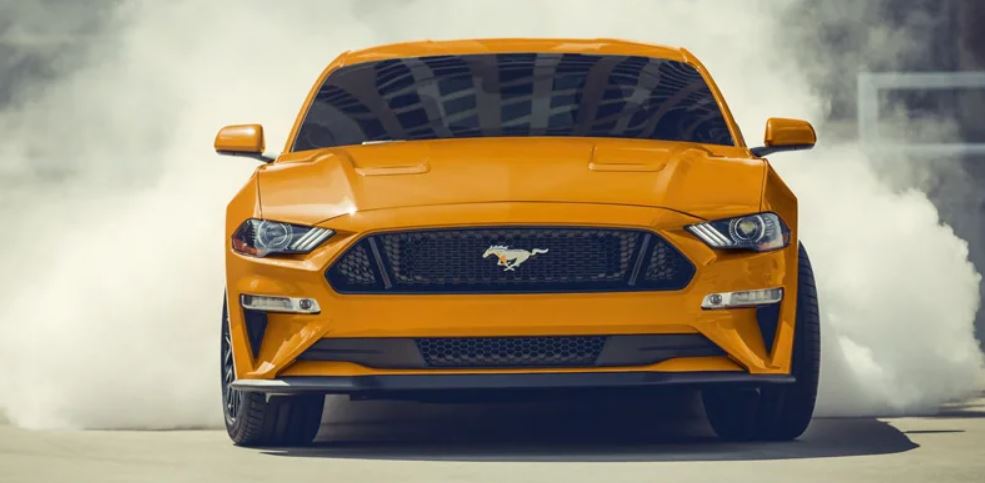 Front view of an orange 2022 Ford Mustang with smoke around the rear. | Ford service center in Little Rock, AR.