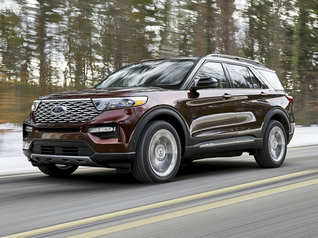 A chocolate brown 2023 Ford Explorer being driven on the road with trees in the background. | Ford dealer in Little Rock, AR | Crain Ford of Little Rock